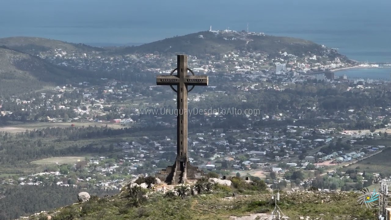 Video aéreo del Cerro Pan de Azúcar con fondo de Piriápolis y sus cerros, Maldonado