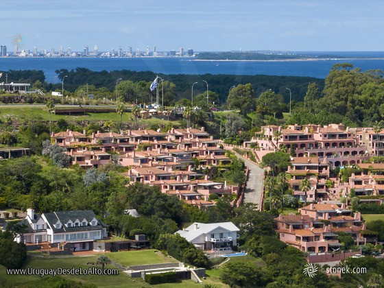 Vista aérea de Terrazas de Portezuelo, mirador, bandera uruguaya, isla Gorriti y Punta del Este